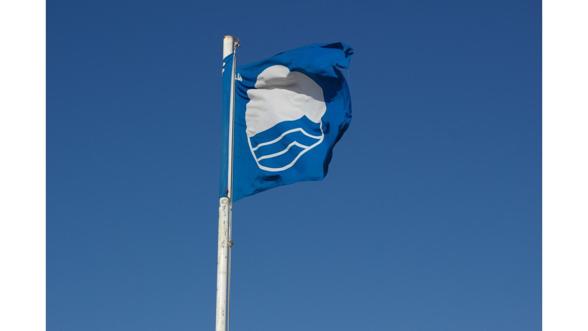 Bandeira Azul hasteada em Bombinhas simbolo de qualidade ambiental e certificacao internacional das praias do municipio scaled - Rocccoimob Imobiliária em Bombinhas