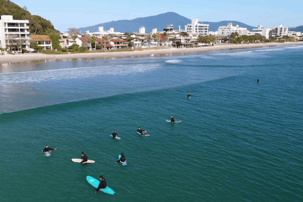 People in the sea in front of residential buildings on the edge of Bombinhas - Roccoimob Real Estate in Bombinhas People in the sea in front of residential buildings on the edge of Bombinhas - Rocccoimob Real estate in Bombinhas