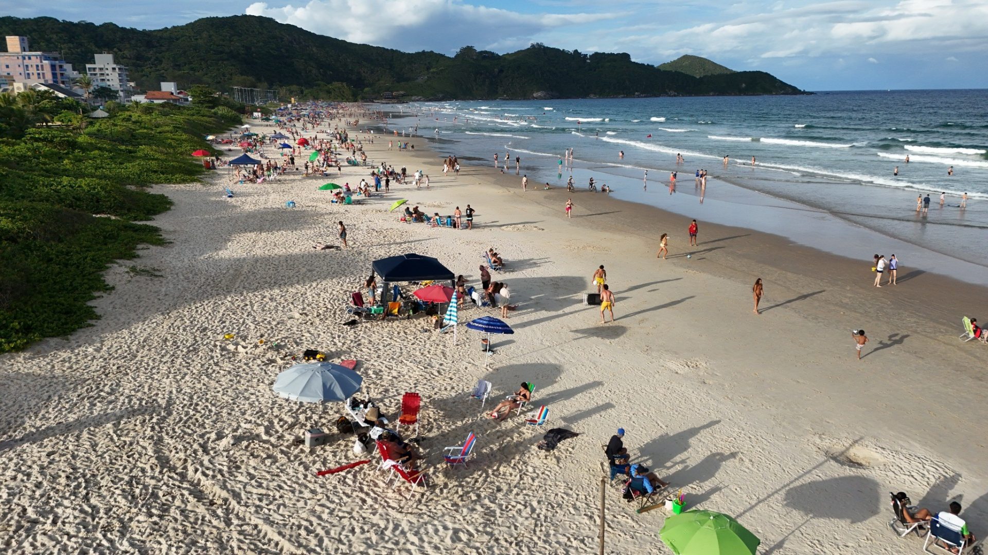 Praia movimentada em Bombinhas durante o verao com turistas aproveitando o sol e o mar scaled - Rocccoimob Imobiliária em Bombinhas