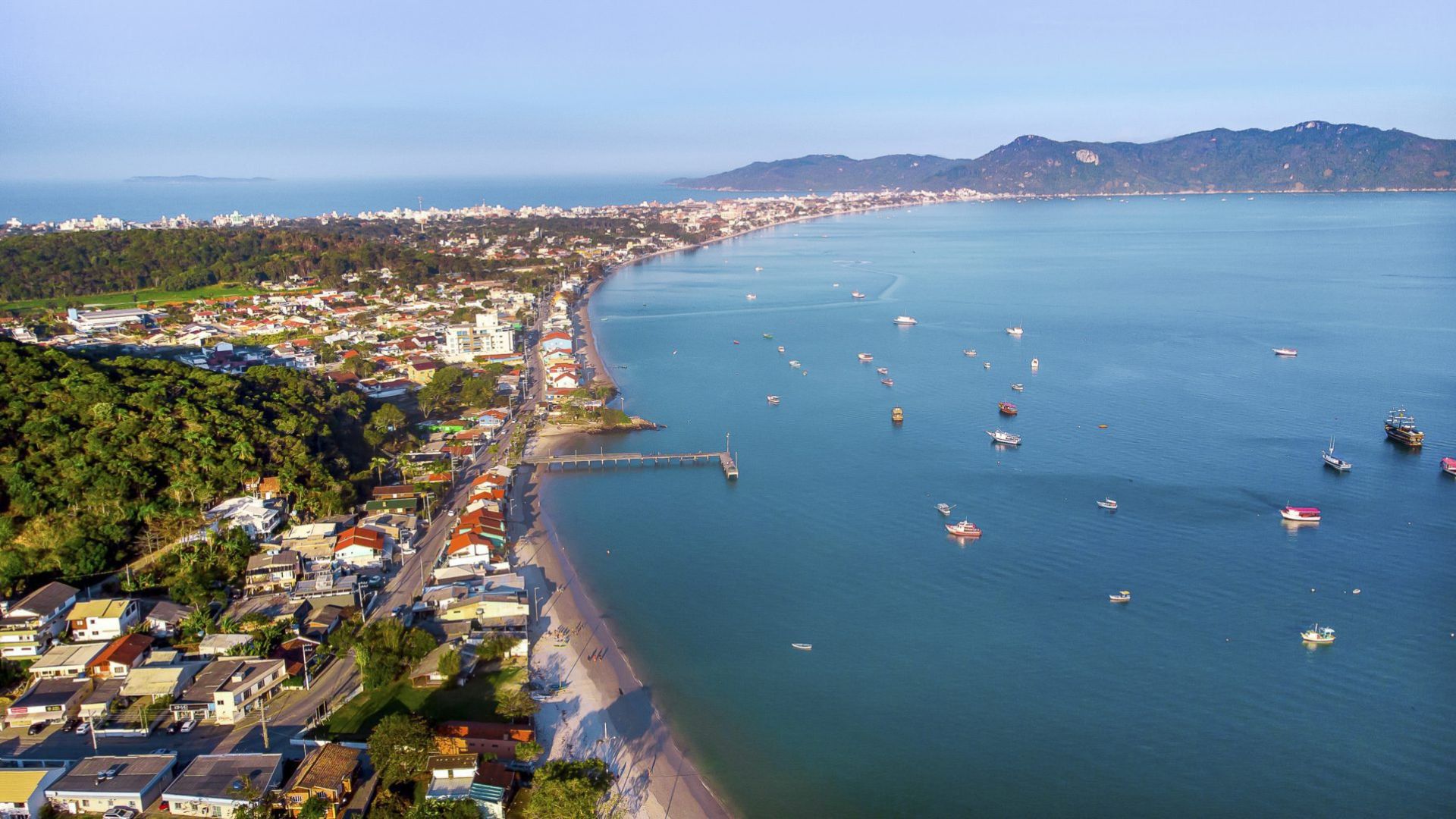 Aerial view of Bombinhas with beach, residential neighborhood and boats, representing the lifestyle on the coast of Santa Catarina. - Rocccoimob Real Estate in Bombinhas 