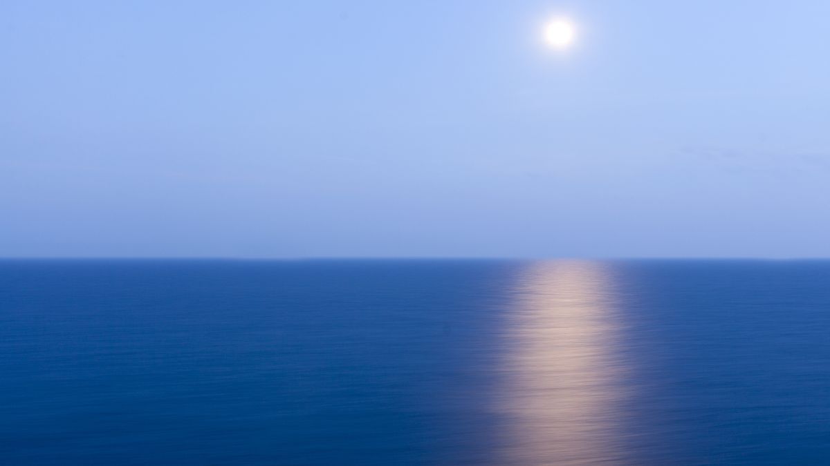 Luna reflejándose en el océano por la noche con mares tranquilos, ilustrando la influencia lunar en las mareas y el comportamiento del nivel del mar - Rocccoimob Real Estate en Bombinhas