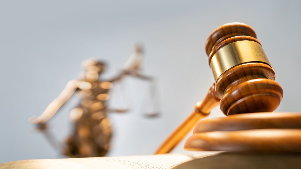 Martillo de la justicia con la estatua de la diosa de la justicia al fondo, representando una decisión judicial sobre el impuesto medioambiental de Bombinhas - Inmobiliaria Rocccoimob en Bombinhas