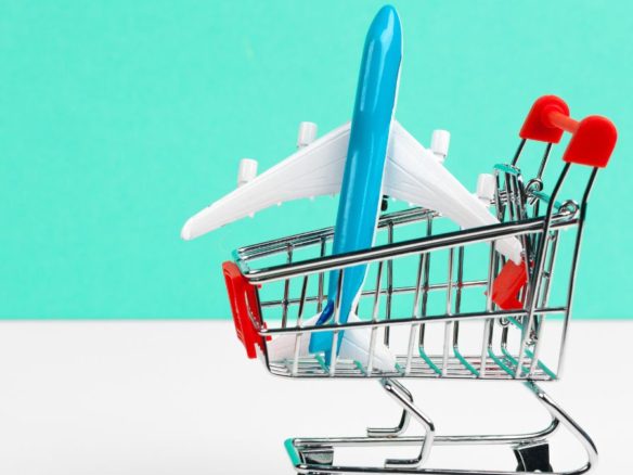 Caddie de courses avec avion jouet représentant l’augmentation des coûts de déplacement et l’impact sur le tourisme et le marché immobilier - Rocccoimob Real Estate à Bombinhas