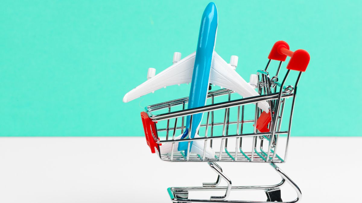 Carrito de la compra con avión de juguete que representa el aumento de los costes de viaje e impacto en el turismo y el mercado inmobiliario - Rocccoimob Real Estate en Bombinhas
