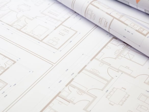 Plano de una propiedad abierta sobre una mesa, destacando la distribución de los entornos y la organización de los espacios para evaluar la funcionalidad del proyecto - Rocccoimob Real Estate en Bombinhas