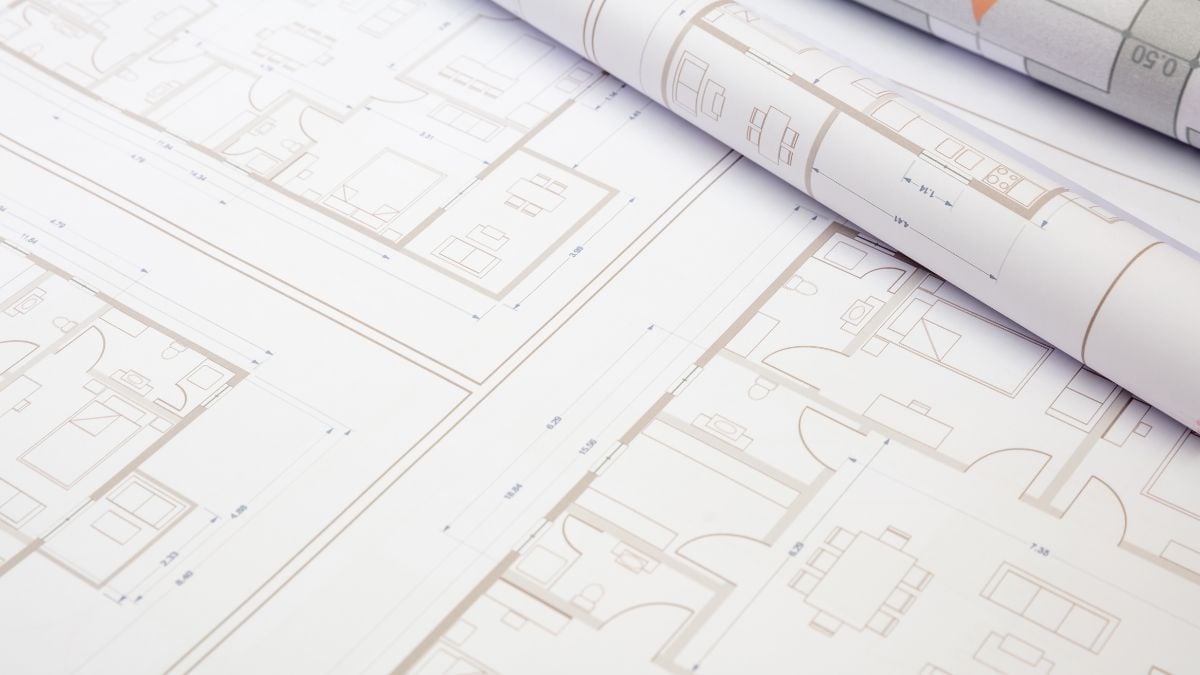 Floor plan of a property open on a table, highlighting the distribution of environments and the organization of spaces to evaluate the functionality of the project - Rocccoimob Real Estate in Bombinhas