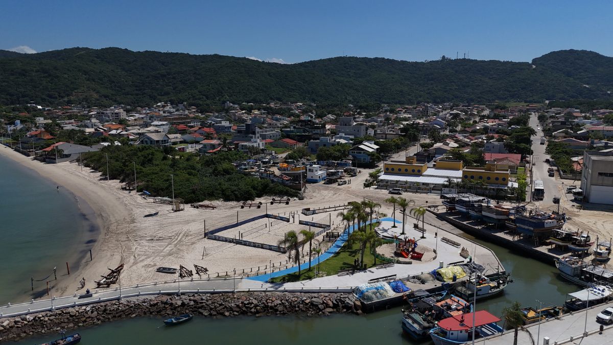 Vista aérea del barrio de Morrinhos mostrando la zona residencial, la infraestructura urbana, el comercio, la marina y el acceso a la playa, destacando características de un barrio con potencial de crecimiento - Rocccoimob Real Estate en Bombinhas